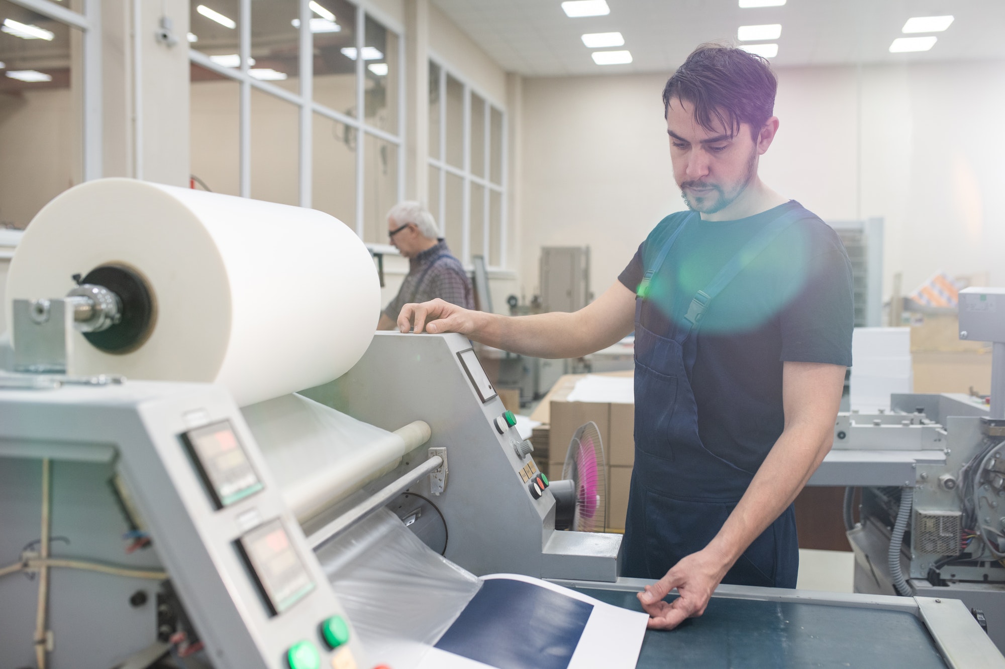 Operating printing press at factory